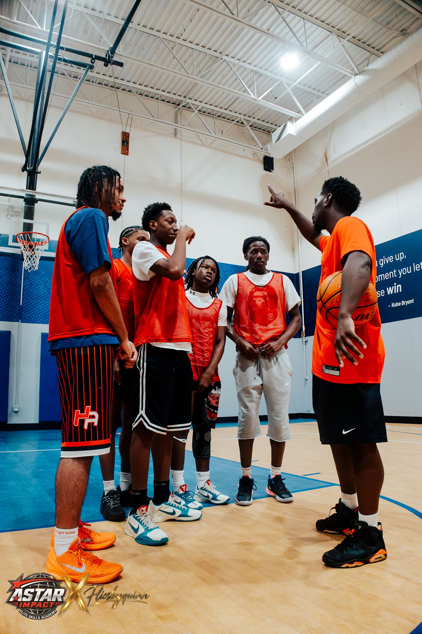 A coach talking with athletes in red pinnies at the 2026 Skills Academy camp
