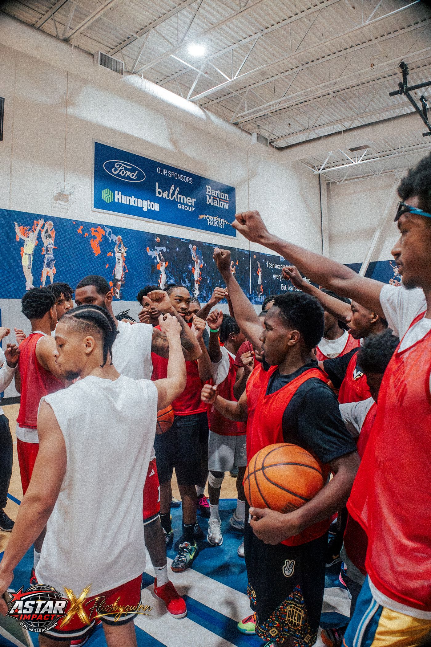 Athletes and coaches huddled with fists raised at the 2026 Skills Academy camp